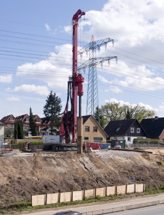 Eine Bohrmaschine, dreimal so hoch wie das Haus dahinter