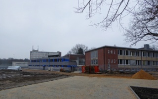 Links das neue Haus für die Sportplätze, rechts noch ein altes der Universität, davor immer noch Baustelle.