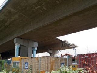 Über dem 1. Pfeiler der Brücke ragen noch die Enden der Stahlseile aus der Abbruchkante.